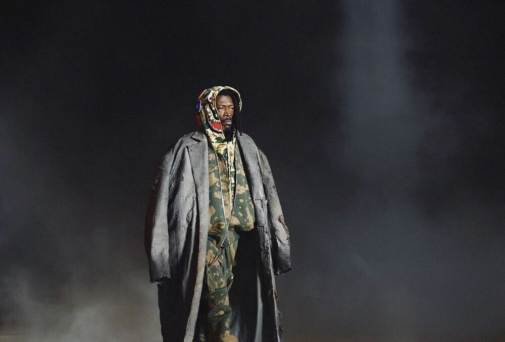 Model in a long coat walking through smoke