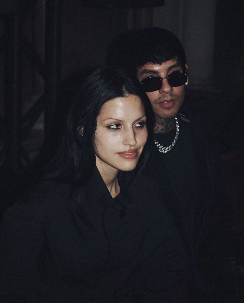 Couple in black close together in a dark room