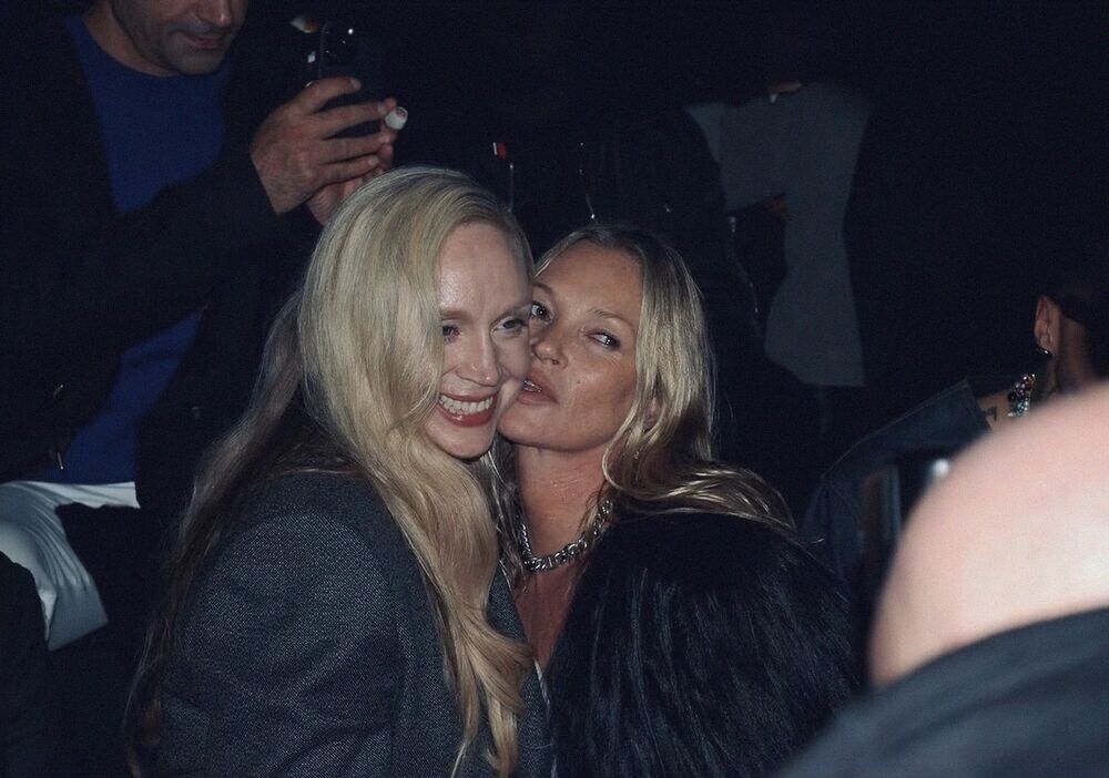 Two women cheek to cheek at a party