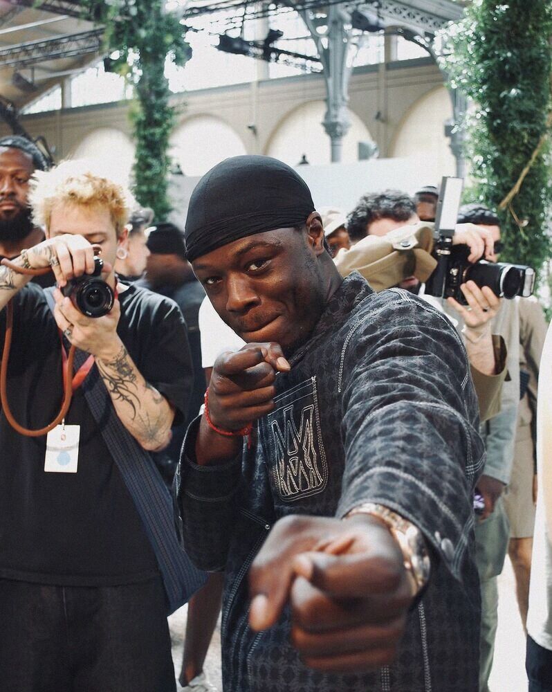 Man pointing at the camera in front of photographers