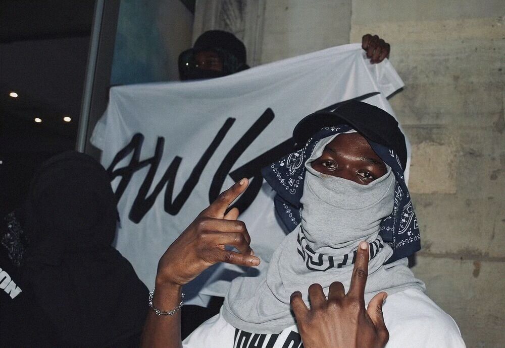 Masked man in front of a banner
