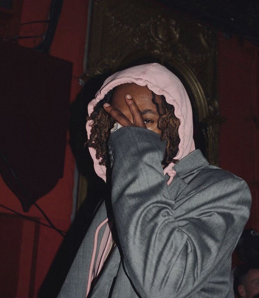 Person in a pink hood hiding their face